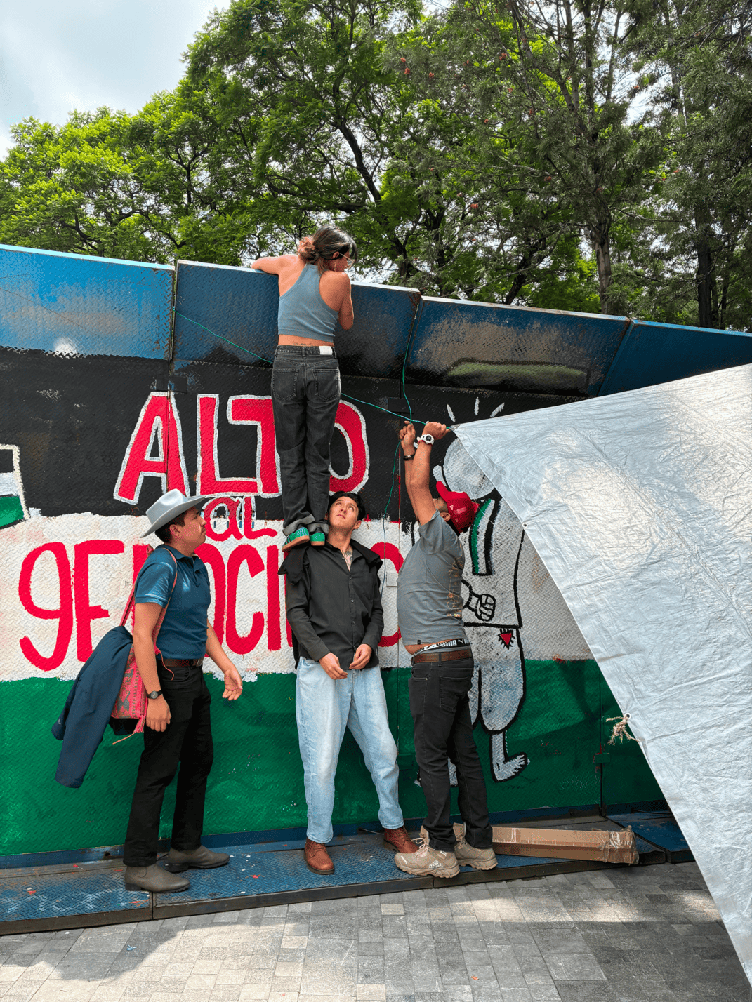 Participants hanging mega banners at the Hemiciclo a Juárez